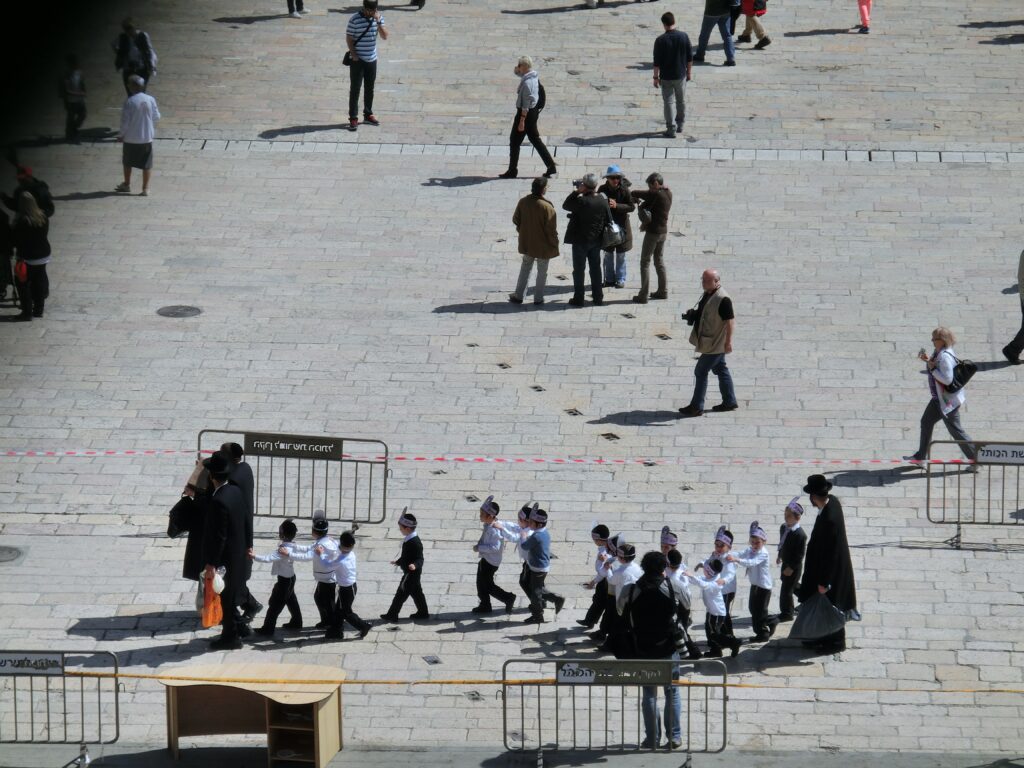 ユダヤ教超正統派の一家。子どもたちが列車ごっこをして歩いています。